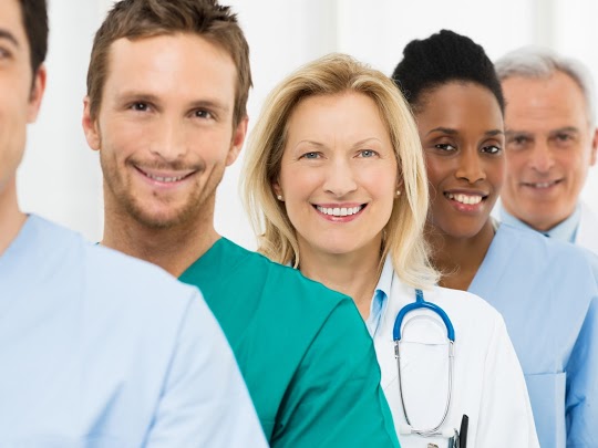 Group Of Happy Successful Doctors Standing In A Row At Hospital
